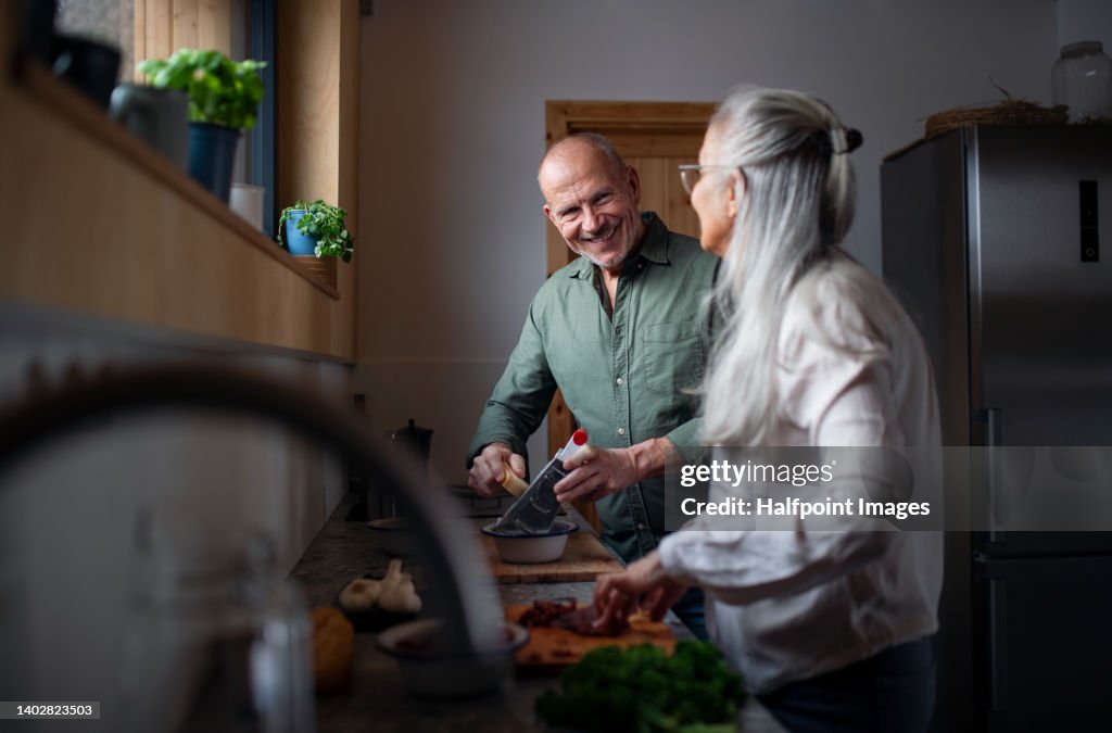 Senior couple preparing meal together in their kitchen.