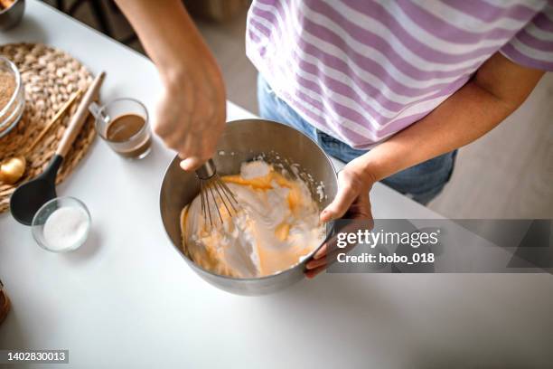 mittlere erwachsene frau, die eine köstliche creme für käsekuchen macht - ausbackteig stock-fotos und bilder