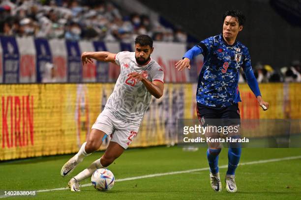 Anis Ben Slimane of Tunisia controls the ball under pressure of Daichi Kamada of Japan during the international friendly match between Japan and...