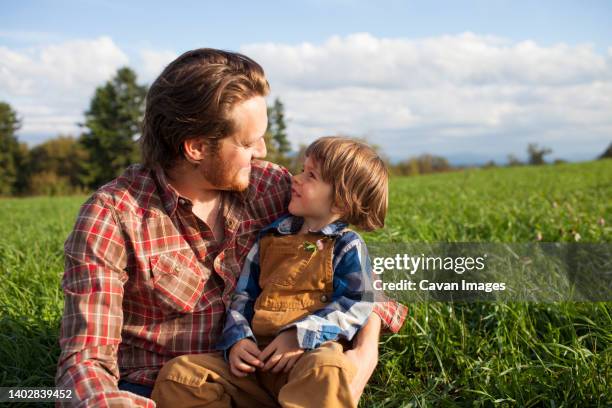 outdoor portrait of a father and son sharing an intimate moment. - eastern usa stock pictures, royalty-free photos & images