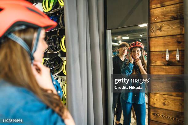 bicycle shop - customer tests a bicycle helmet for road safety - sales competition stock pictures, royalty-free photos & images