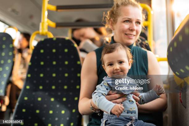 mother and son in the bus - mum sitting down with baby stockfoto's en -beelden