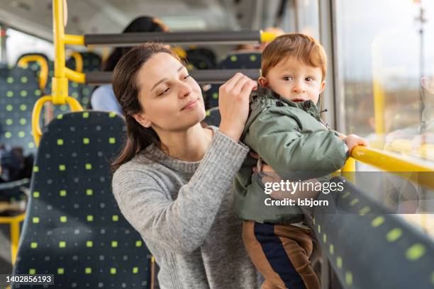 junge mutter und sohn im bus - kids sitting together in bus stock-fotos und bilder