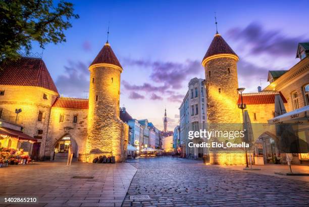 viru gate with tallinn town hall on background - tallinn, estonia - baltische landen stockfoto's en -beelden
