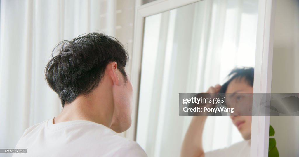Uomo preoccupato per la caduta dei capelli