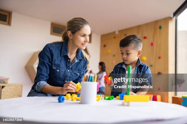 happy teacher playing with a boy in the classroom - terapia ocupacional imagens e fotografias de stock