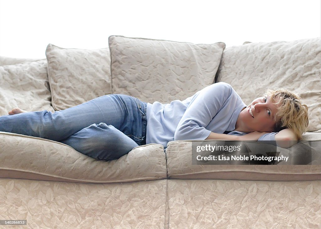 Woman reclining on white sofa