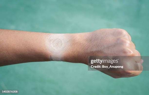 tan line on men's hand after taking off a sports watch with a clear and visible tan line from wearing watch longtime. - sunburnt stock pictures, royalty-free photos & images