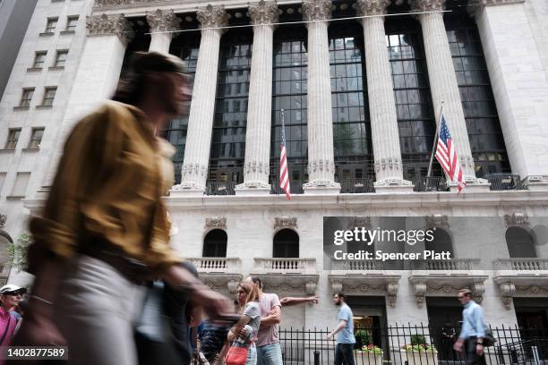 People walk by the New York Stock Exchange on June 14, 2022 in New York City. The Dow was up in morning trading following a drop on Monday of over...