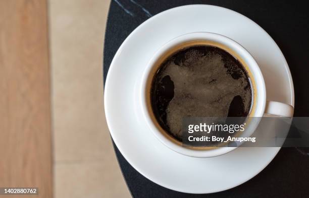table top view of a cup of black coffee on table. - crema stock pictures, royalty-free photos & images