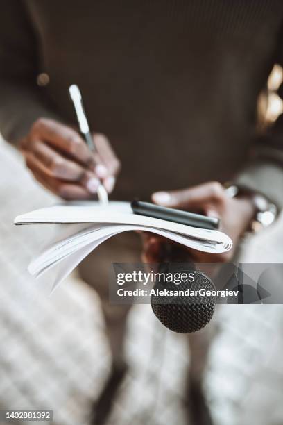 african male journalist writing questions for press conference - joy press conference stockfoto's en -beelden