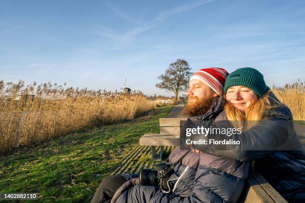 a loving couple man and woman in winter warm clothes embracing - dutch culture stock photos et images de collection