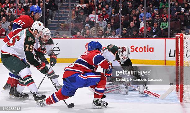 David Desharnais of the Montreal Canadiens deflects a pass from Max Pacioretty behind goaltender Josh Harding of the Minnesota Wild during the NHL...