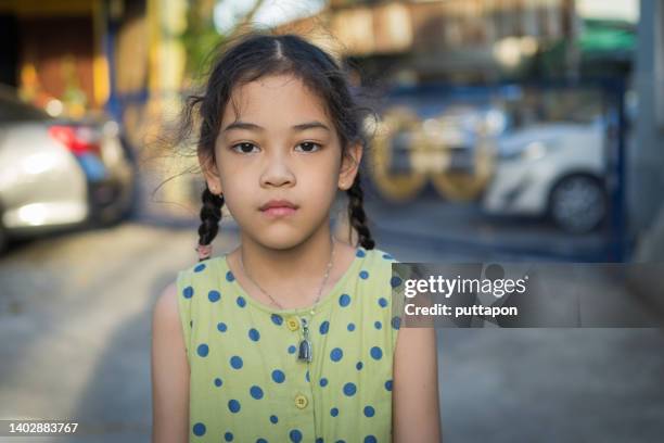 portrait of a young asian girl in various moods and looking at the camera - stock photo - studio head shot serious confident looking at camera foto e immagini stock