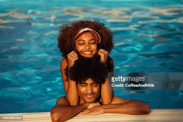 portrait of young beautiful afro men and woman swimming in the pool - beautiful black women in bathing suits stock pictures, royalty-free photos & images