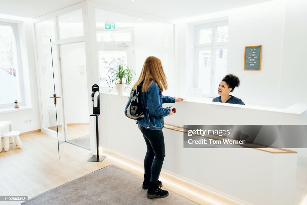Customer Talking To Dental Practice Receptinoist