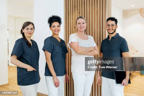 portrait of staff together in family dental practice - dental hygienist stock-fotos und bilder