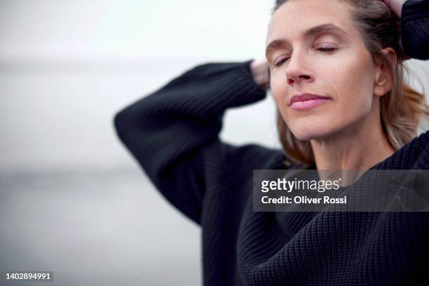 portrait of woman with closed eyes on the beach - serene people stock-fotos und bilder