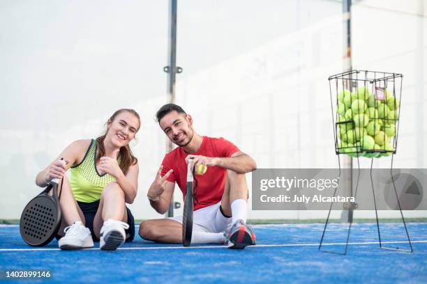 happy couple looking at camera in paddle tennis class - pudel stock pictures, royalty-free photos & images