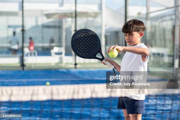 niño pequeño jugando al pádel en la pista - pala de tenis de mesa fotografías e imágenes de stock