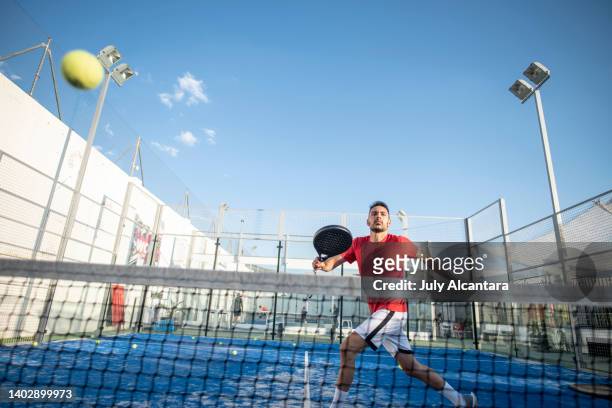 man playing paddle tennis in court , ready for smash in sports class - pudel stock pictures, royalty-free photos & images