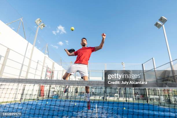 man playing paddle tennis in court , ready for smash in air - paddle tennis stock pictures, royalty-free photos & images