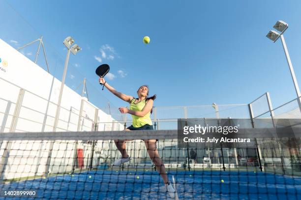 woman playing paddle tennis in court , ready for smash jumping in training sports class - using a paddle imagens e fotografias de stock