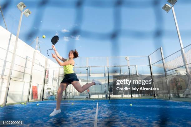 femme jouant au paddle-tennis sur le court, prête pour le smash jumping en cours de sport d’entraînement - paddle tennis photos et images de collection