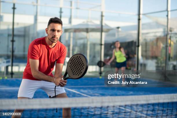 couple playing paddle tennis in court - paddle tennis stock pictures, royalty-free photos & images