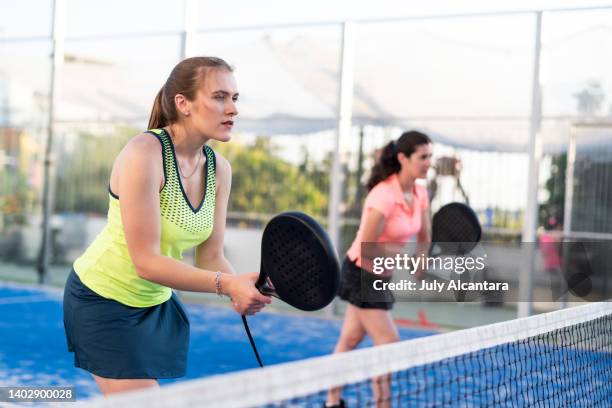 two women playing paddle tennis in court, padel training - paddle tennis stock pictures, royalty-free photos & images