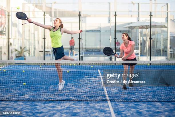 two women playing paddle tennis in court, padel training - racquet stockfoto's en -beelden