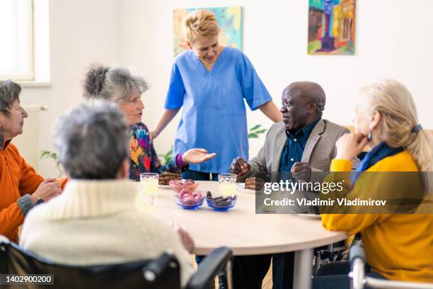 a female medical orderly working with senior citizens - residential care stock pictures, royalty-free photos & images