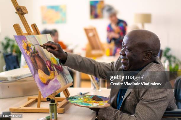 retired pensioner painting for therapy - male artist painting stock pictures, royalty-free photos & images