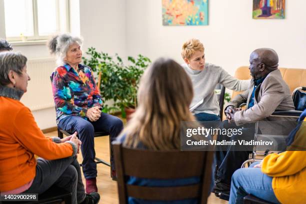 a caring clinician offers sympathy to an elderly man - meeting of the international syria support group stockfoto's en -beelden