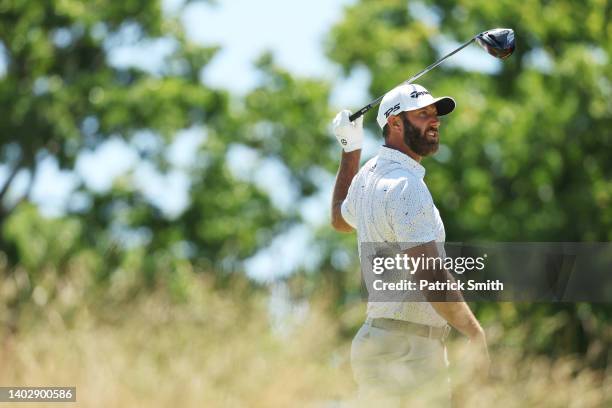 Dustin Johnson of the United States watches his shot from the tenth tee during a practice round prior to the US Open at The Country Club on June 14,...