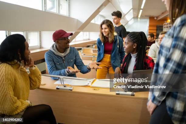 a group of students hold a quick discussion - college students diverse stock pictures, royalty-free photos & images