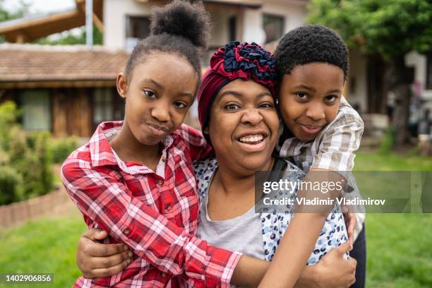 a family hug in the backyard - jamaicaanse etniciteit stockfoto's en -beelden
