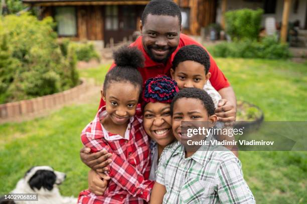 portrait of a happy afro-american family hugging together - jamaicaanse etniciteit stockfoto's en -beelden