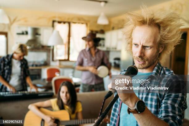 scream of male angry rocker at the microphone - gig living room stock pictures, royalty-free photos & images