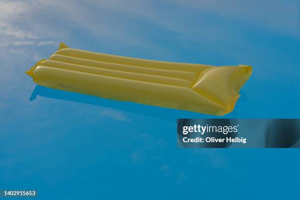 one single yellow air mattress in a empty pool - plastic pool stock-fotos und bilder