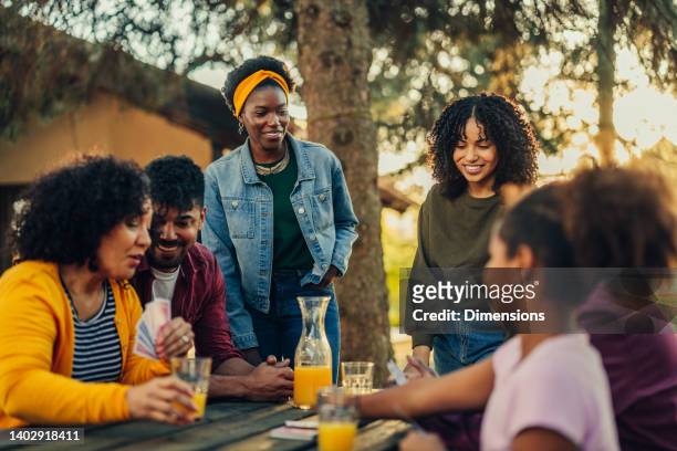family gathering in the courtyard, playing cards - woman playing squash stock pictures, royalty-free photos & images