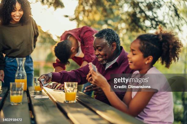 family spending a day outdoors and playing board game - woman playing squash stock pictures, royalty-free photos & images
