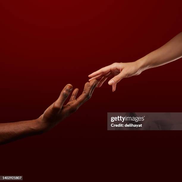 two hands reaching for each other. human relations, trust, unity, togetherness, symbolism concept - origin stock pictures, royalty-free photos & images