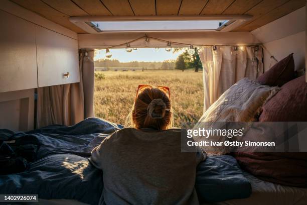 frau mit blick auf die rückseite eines wohnmobils - camping stock-fotos und bilder