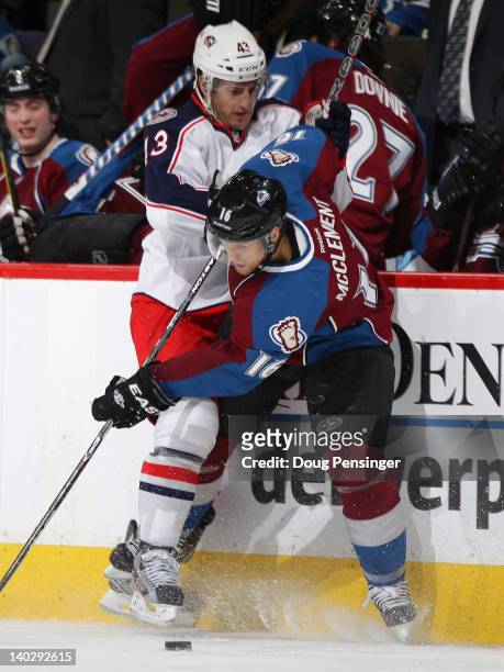 Darryl Boyce of the Columbus Blue Jackets puts a hit on Jay McClement of the Colorado Avalanche at the Pepsi Center on March 1, 2012 in Denver,...