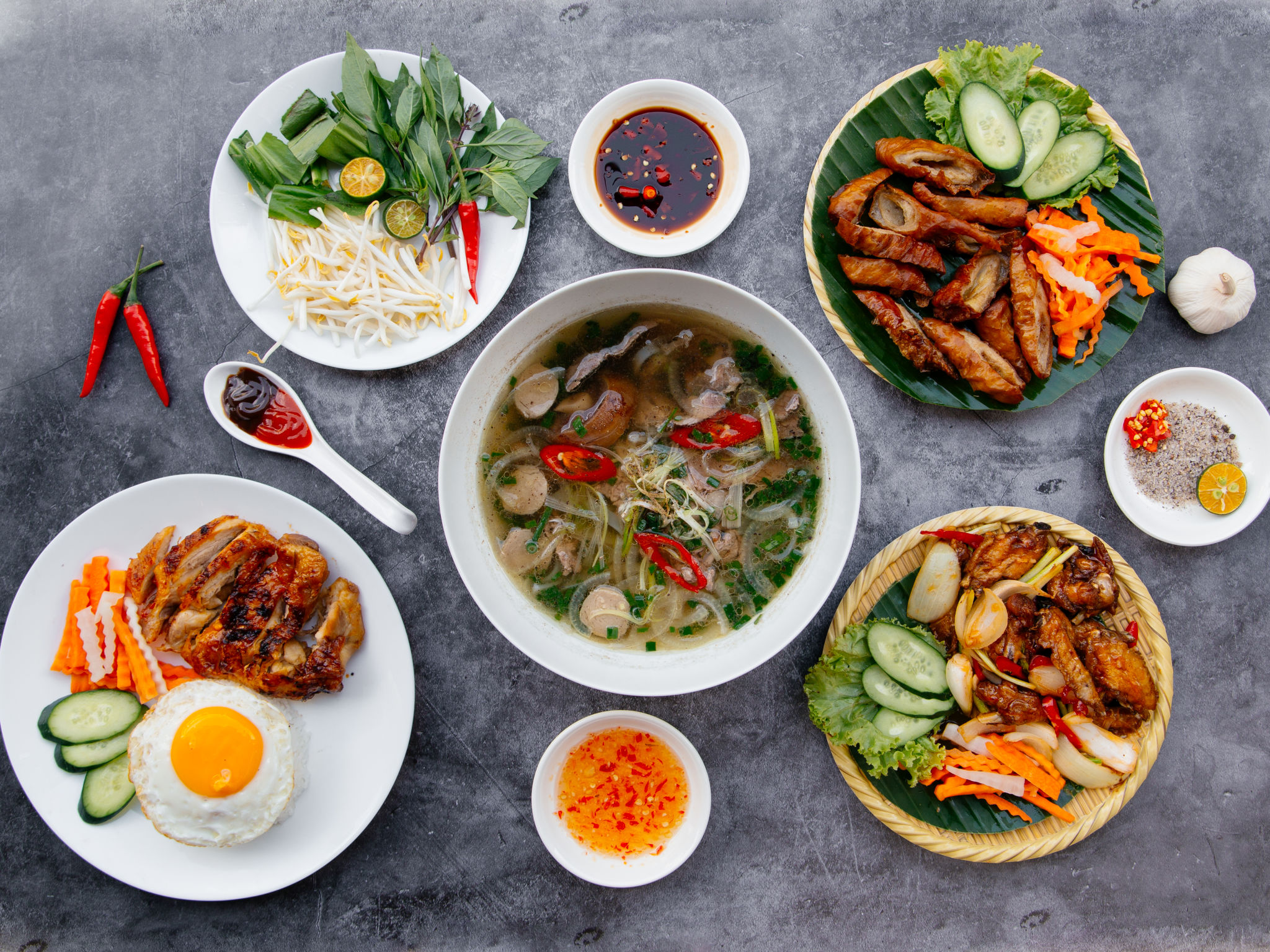 Beef Pho, Grilled Chicken, Deep Fried Pig Intestine, salad served in bowl isolated on dark grey background top view of japanese food Beef Pho, Grilled Chicken, Deep Fried Pig Intestine, salad served in bowl isolated on dark grey background top view of japanese food