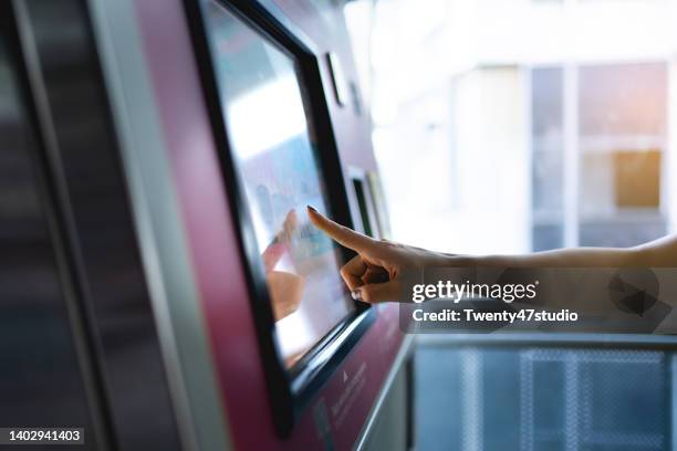 woman buying a subway ticket on the ticket machine in the station - train ticket stock pictures, royalty-free photos & images