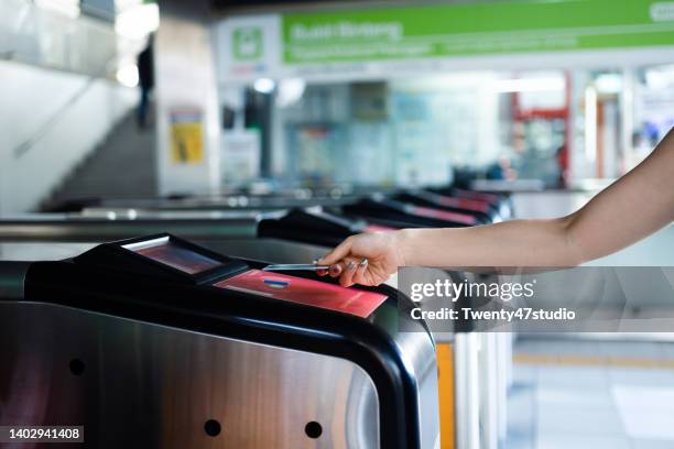 close up woman checking out at subway station using contactless payment for subway ticket card - train ticket stock pictures, royalty-free photos & images