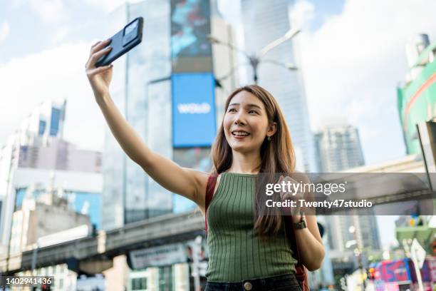 cheerful young asian woman traveling at bukit bintang crossing the city center of kuala lumpur - bukit bintang stock pictures, royalty-free photos & images