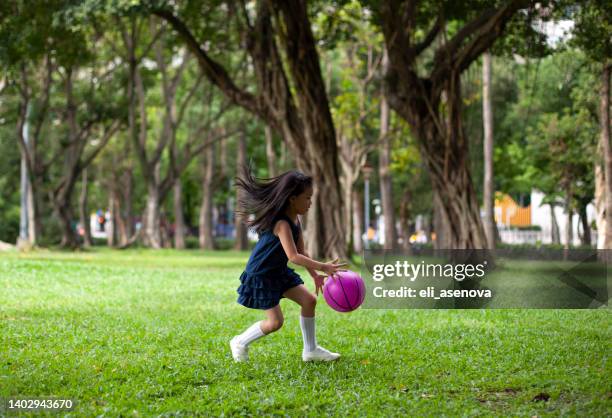 little asian girl playing with a soccer ball in park taipei - girl kicking stock pictures, royalty-free photos & images